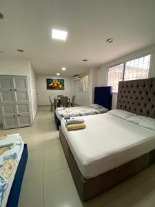a bedroom with three beds and a dining room with a table at Posada Dakema in Cartagena de Indias
