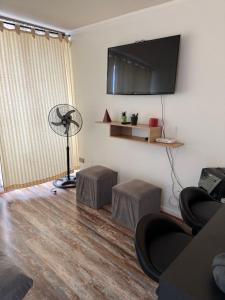 a living room with a fan and a table and stool at 2108 Depto a 15 minutos del Aeropuerto frente mall in Santiago