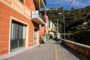 an empty street next to a orange building at camere Caterina in Bonassola