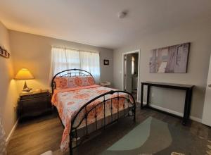 a bedroom with a bed and a lamp and a window at Bay Front Manor House in Deale