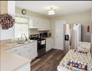 a kitchen with white cabinets and a stainless steel refrigerator at Bay Front Manor House in Deale +20 photos