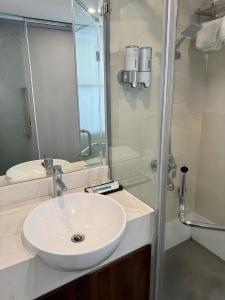a bathroom with a white sink and a shower at Mercy Hotel in Hanoi