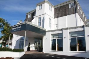 a white building with a sign on it at Belgrave Sands Hotel & Spa in Torquay
