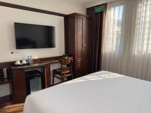 a hotel room with a bed and a television at Mercy Hotel in Hanoi +18 photos