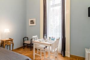 ナポリにあるCasAlice Mini Apartments Napoliのテーブルと椅子、窓が備わる客室です。