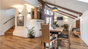 a kitchen and dining room with a dining table and a living room at Ferienwohnung Schmickhof in Gaißach