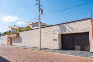 a white brick building with a garage on a street at Casa del abuelo in Tehuacán