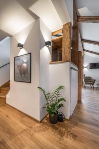 a living room with a potted plant and a wall at Ferienwohnung Schmickhof in Gaißach