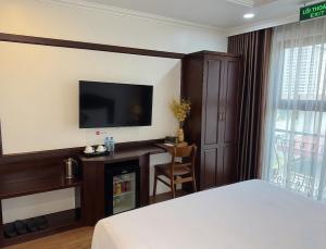 a hotel room with a bed and a television at Mercy Hotel in Hanoi