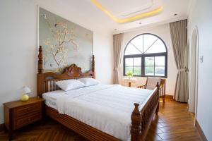 a bedroom with a large bed and a window at AT Homestay Huế in Thôn Lại Thê