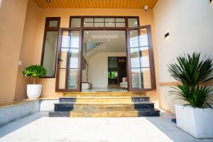 a building with stairs and plants in front of it at AT Homestay Huế in Thôn Lại Thê