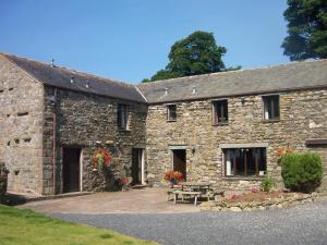 een stenen gebouw met een picknicktafel ervoor bij Stable Barn in Penrith