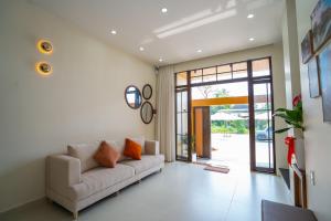 a living room with a couch and a sliding glass door at AT Homestay Huế in Thôn Lại Thê
