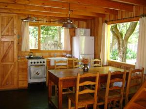 a kitchen with a wooden table and a refrigerator at El Recodo in San Martín de los Andes