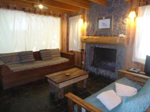 a living room with a couch and a fireplace at El Recodo in San Martín de los Andes