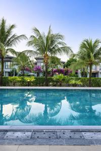a swimming pool with palm trees in the background at Luxury villa Phu Quoc in Phú Quốc
