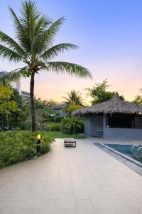 a patio with a bench and a palm tree at Luxury villa Phu Quoc in Phú Quốc