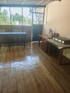 an empty room with a table and a wooden floor at Celestial Homestay in Wayanad