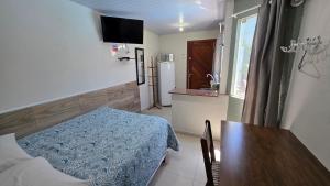 a small room with a table and a kitchen at Pousada Marques Floripa in Florianópolis