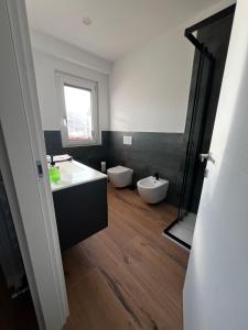 a bathroom with two toilets and a sink and a mirror at Mood Valentina in Goriano Sicoli +10 photos