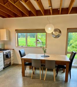 a dining room with a wooden table and chairs at Beech Hill - Pet Friendly Holiday Home in Tasman