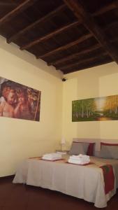ローマにあるナヴォーナ スタジオ アパートメントのベッドルーム1室(ベッド1台付)が備わります。壁には絵画が飾られています。