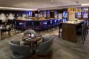 a restaurant with tables and chairs and a bar at Marriott Birmingham Grandview in Acton