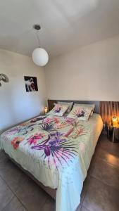 a bedroom with a large bed with a colorful comforter at AU GRAIN D'ORGE in Échiré