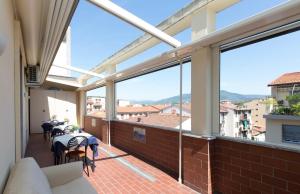 d'un balcon avec des tables et des chaises et de grandes fenêtres. dans l'établissement Il Grillo Di Firenze B&B, à Florence
