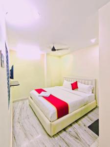 a bedroom with a bed with a red and white blanket at HOTEL VAJRA Grand in Tirupati
