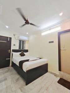 a bedroom with a bed with a ceiling fan at HOTEL VAJRA Grand in Tirupati +1 photo