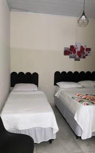 two beds sitting next to each other in a bedroom at Belo Hotel in Ribas do Rio Pardo