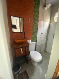 a bathroom with a toilet and a sink and a mirror at Belo Hotel in Ribas do Rio Pardo