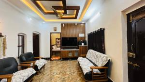 a living room with two couches and a television at Odrine's abode - Udupi in Kalyānpur