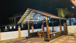 a table and chairs on a balcony at night at Odrine's abode - Udupi in Kalyānpur