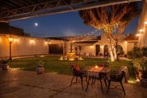 a patio with a table and chairs in a yard at night at Casa del abuelo in Tehuacán