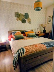 a bedroom with a large bed with colorful pillows at chambre d'hôte chez Mimidid in Le Landreau