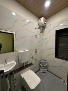 a bathroom with a toilet and a sink at Hotel Vyankatesh Inn in Nashik