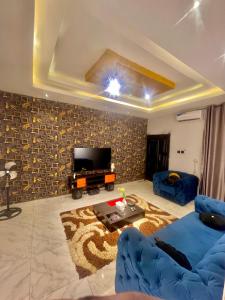 a living room with a blue couch and a television at Ebest homes in Benin City
