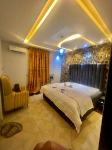 a bedroom with a large bed and a chair at Ebest homes in Benin City