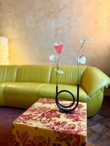 two flowers sitting on a table in front of a couch at Maison Stefana Rynek in Rzeszów