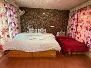 a bedroom with a large bed with a red blanket at Mughal resort pahalgam in Pahalgām