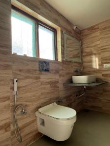 a bathroom with a toilet and a sink at Mughal resort pahalgam in Pahalgām