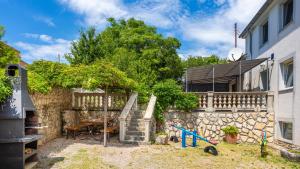 a backyard with a table and a stone wall at Villa Risika 2 with pool island Krk by Villas Guid in Risika