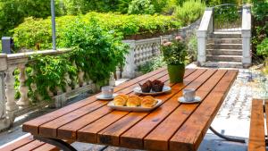 a wooden table with two plates of food on it at Villa Risika 2 with pool island Krk by Villas Guid in Risika
