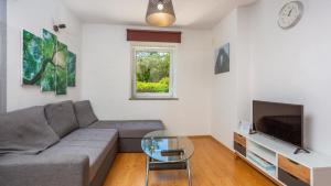 a living room with a couch and a television at Villa Risika 2 with pool island Krk by Villas Guid in Risika
