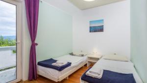 two beds in a room with a window at Villa Risika 2 with pool island Krk by Villas Guid in Risika +27 photos