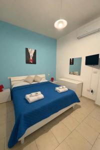 a blue bedroom with a bed with two towels on it at Supera Home in Gallipoli