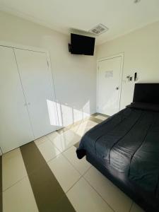 a bedroom with a black bed and a tiled floor at Guest Room in Joan in St Albans