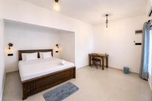 a bedroom with a bed and a table in it at Stara Weligama in Weligama